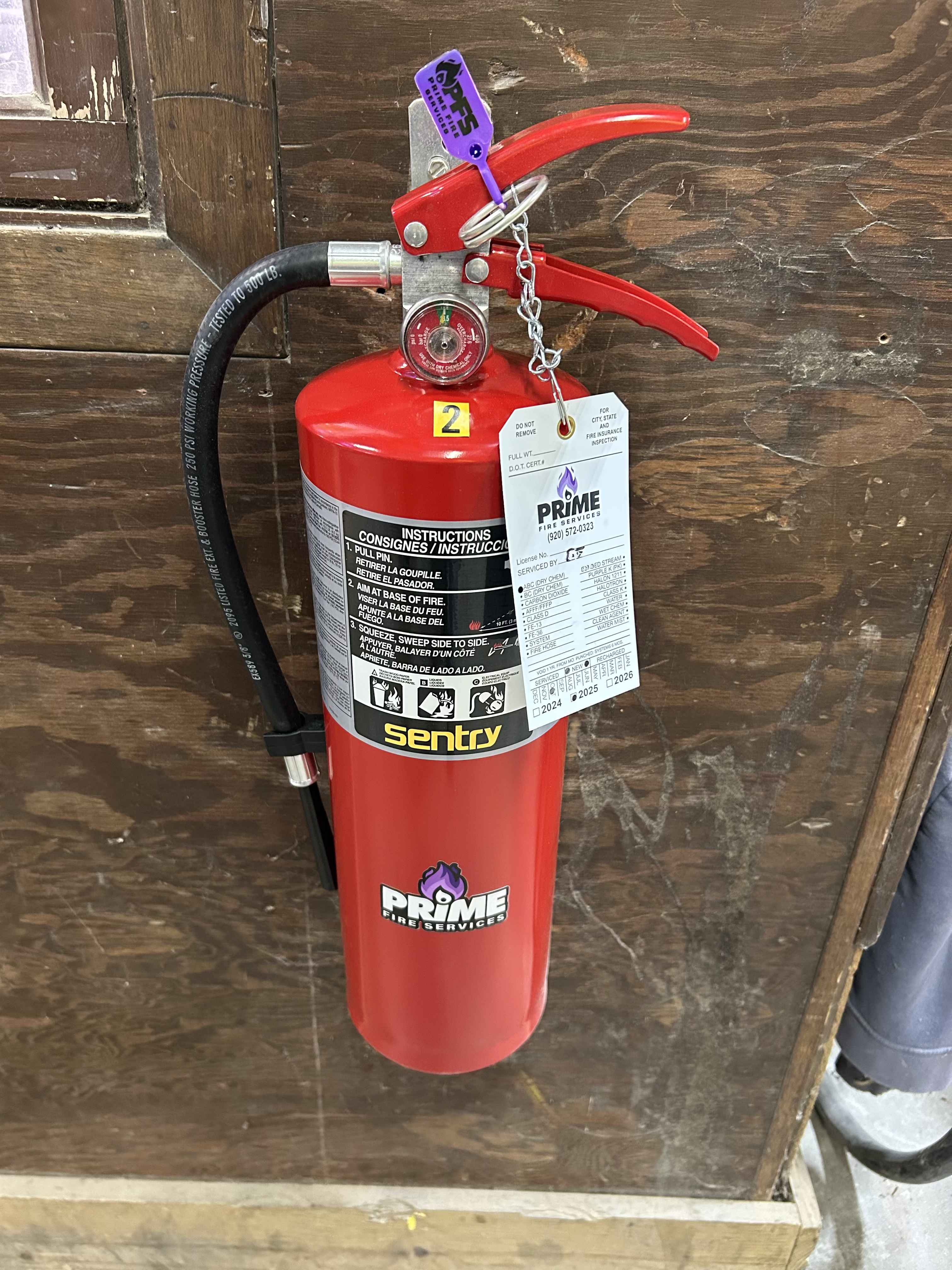 Commercial fire extinguisher properly mounted and tagged