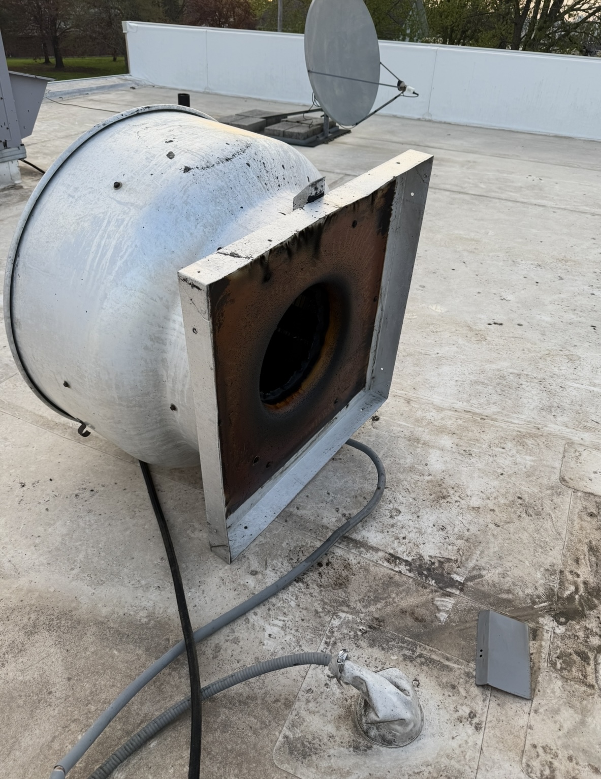 Rooftop exhaust fan with dangerous grease buildup before cleaning